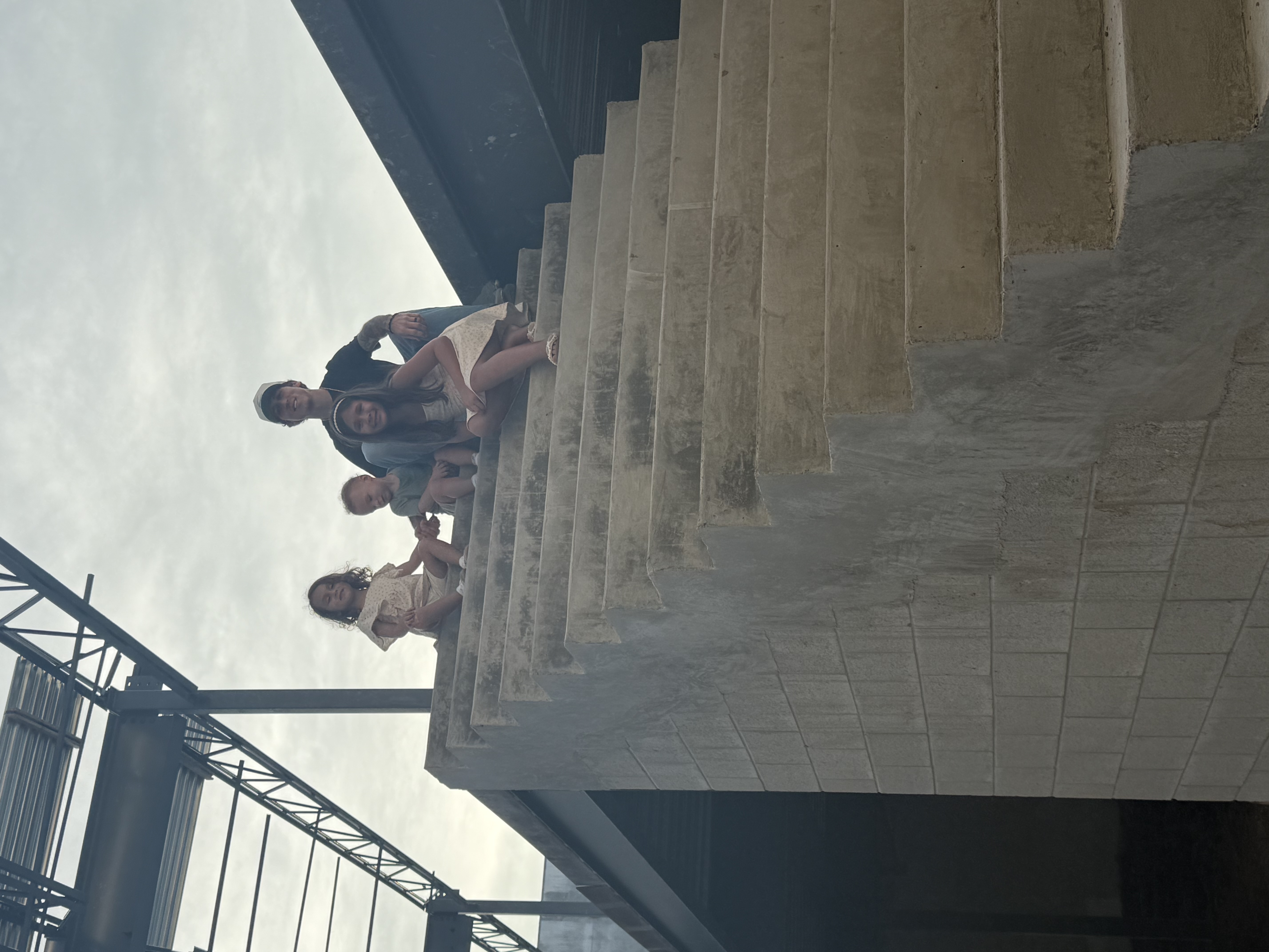 Children sitting on an unfinished staircase at Palms Manor